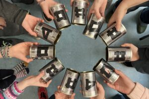 Kinderhände strecken Lochkameras aus Konservendosen ins Bild